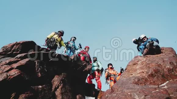 登山者的陪伴站在山顶上高兴而微笑地举起双手操作员移除视频的预览图