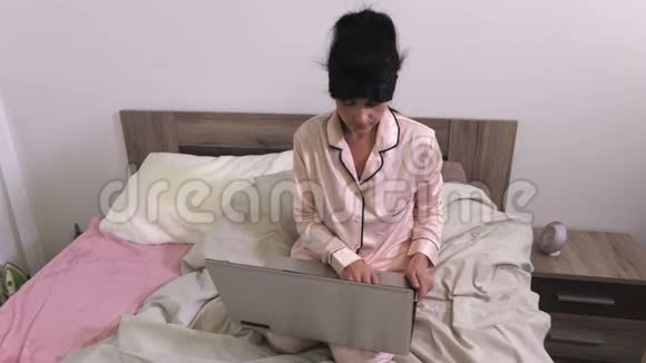 在睡觉前女人使用笔记本电脑视频的预览图