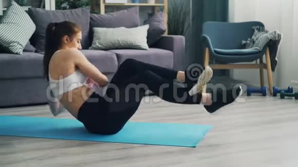 有魅力的女孩在家里在瑜伽垫上做运动训练腹部肌肉视频的预览图