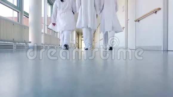 三位医生在医院的走廊上散步视频的预览图