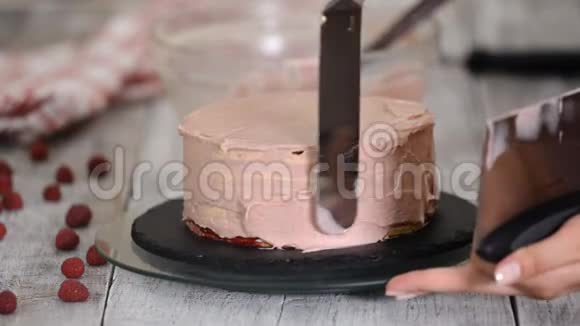 女孩把蛋糕上的奶油弄平了自制糕点烹饪蛋糕的概念视频的预览图