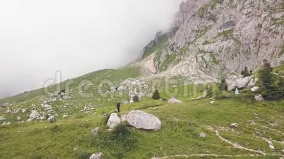 站在山边石头上的女人背景是雾谷无人机的景色视频的预览图