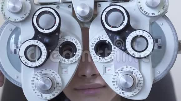年轻女性眼科医生用光翅目闭眼检查可爱的女人微笑着透过视频的预览图