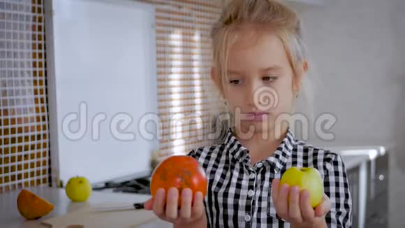 快乐可爱的女孩带水果在厨房孩子们健康的饮食观念健康饮食厨房里的孩子视频的预览图