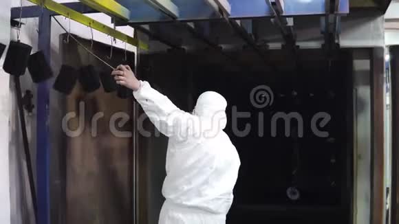 一个穿着防护服的人打开烤箱的门把细节带到那里视频的预览图