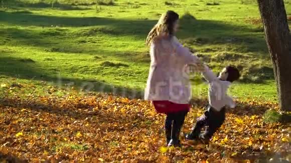 妈妈和她的小儿子在秋天的森林里玩得很开心妈妈在转她儿子他们在笑家庭是视频的预览图