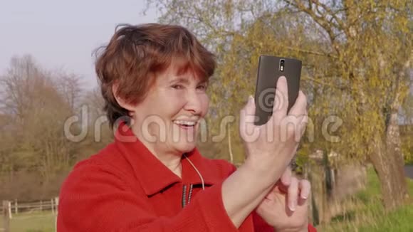 高级女性在外面用手机自拍简介视频的预览图