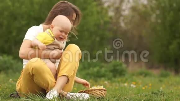 愤怒的婴儿在她母亲的怀里孩子在哭妈妈平静下来在公园野餐的女人和孩子视频的预览图