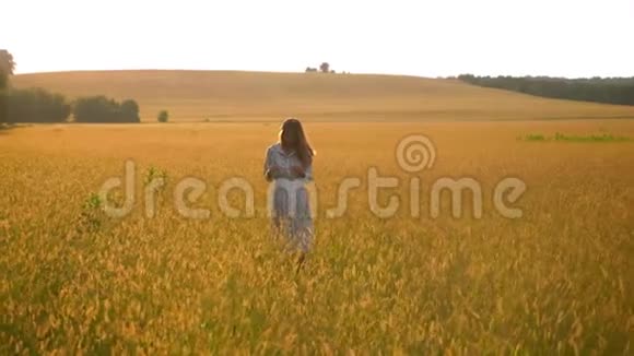美丽的亚洲女人站在黄草地上欣赏大自然视频的预览图