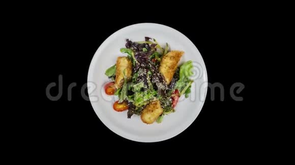 沙拉与三文鱼在面包屑与生菜和芝麻孤立在黑色背景上视频的预览图
