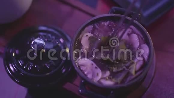 带蘑菇和面条的美味汤放在金属碗里桌子上有一个蓝色的盖子视频的预览图