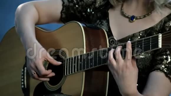一个脖子上戴着项链的女孩弹声吉他右手触弦左手握弦视频的预览图