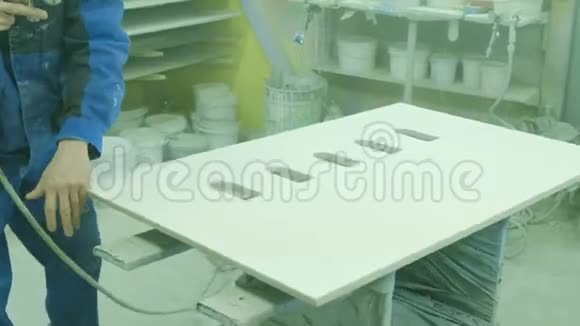 一名工人在一家家具厂用油漆喷头油漆家具的细节油漆室视频的预览图