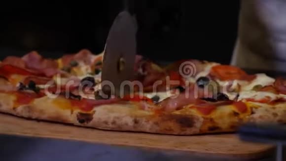 厨师的双手戴着黑色防护手套用培根和西红柿切下一份新鲜美味的披萨视频的预览图