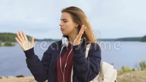 一个十几岁的女孩在河岸上跳舞视频的预览图