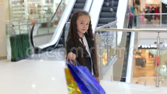 一个可爱的小女孩在一个购物中心的肖像靠近扶梯视频的预览图