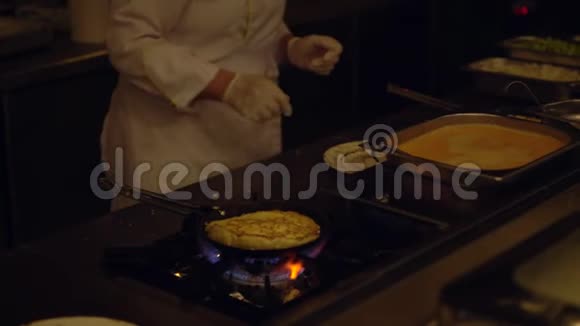 厨师在燃烧机上准备鸡蛋煎蛋卷视频的预览图