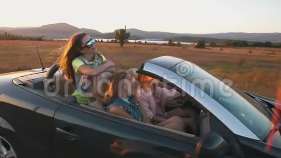 年轻女性在敞篷车里玩视频的预览图