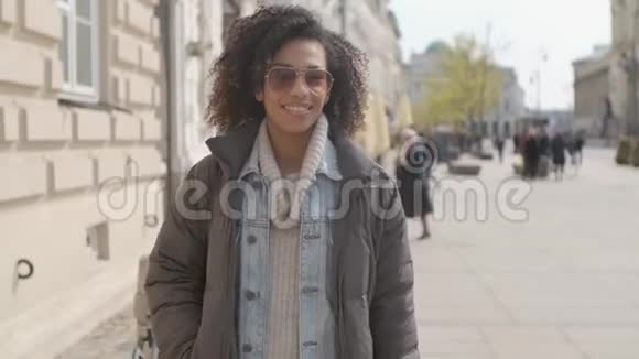 年轻美丽的混血女人带着非洲发型走路的肖像视频的预览图