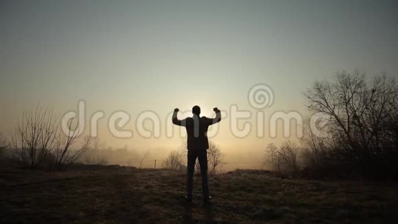 快乐成功的人在日出或日落时庆祝快乐自由他举起双手再次欢呼视频的预览图