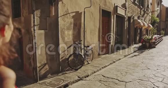 在佛罗伦萨狭窄的街道上散步的年轻女士视频的预览图