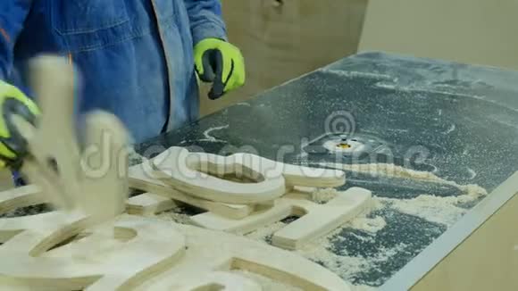 一个人在家具厂用半径切割器移除倒角木制家具的制造视频的预览图