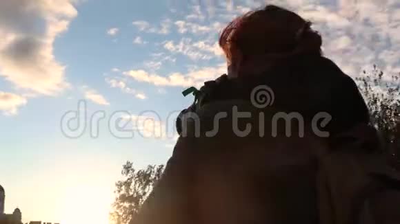 4k录像城市的日落一位年轻的女摄影师视频的预览图