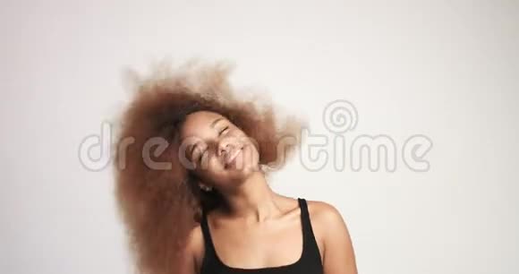 有着一头巨大的非洲头发的贝维特黑人女人开心地笑着跳舞视频的预览图