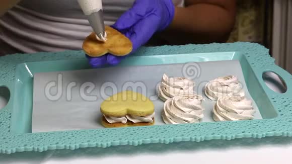 做白色棉花糖三明治的女人将棉花糖应用于饼干饼干和托盘上视频的预览图