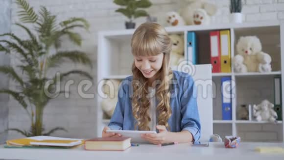 10岁的女孩在平板电脑上看视频视频的预览图
