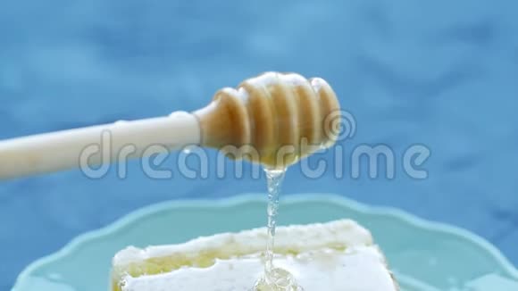 自然生态食品理念手拿纺锤做蜂蜜盘子里的甜蜜蜂视频的预览图
