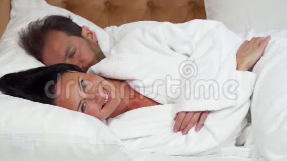 快乐成熟的女人和丈夫躺在床上视频的预览图