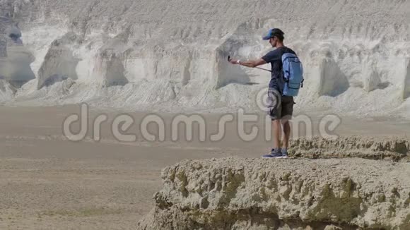 一位年轻的旅行者站在悬崖边上自拍视频的预览图