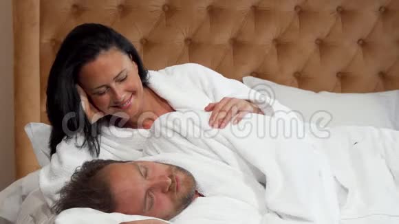 成熟的男人醒来看到他美丽幸福的妻子用爱向她微笑视频的预览图
