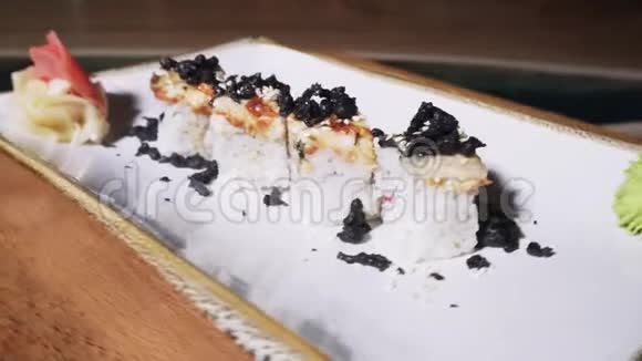 近距离观看4个美味的欧洲卷与鳗鱼芥末和生姜铺设在一个白色的旋转板框架视频的预览图