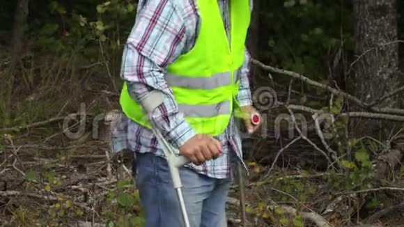 在树林里用拐杖受伤的工人视频的预览图