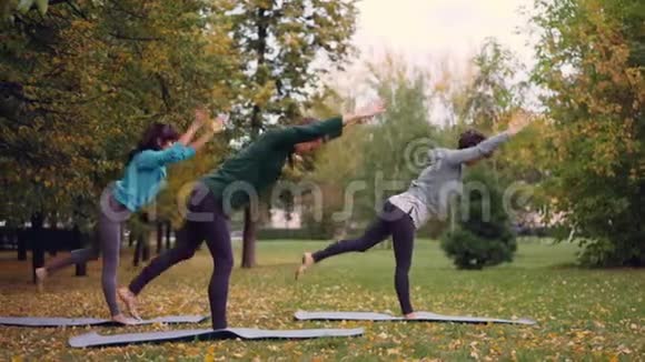 瘦小的年轻女性正在户外锻炼向前和向后伸展身体和手臂娱乐视频的预览图