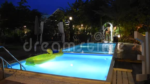 夜间可观赏景观花园和草坪有游泳池可供度假视频的预览图