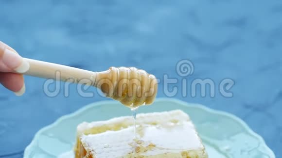 自然生态食品理念手拿纺锤做蜂蜜盘子里的甜蜜蜂视频的预览图