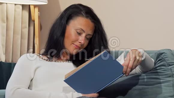 劳累的成熟女人在下班后在家读书时睡着了视频的预览图