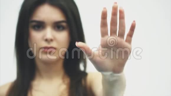 一位年轻女子张开双手站着的肖像显示出在白色背景下姿势停止孤立视频的预览图