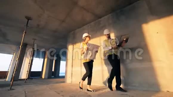 一个女人和一个男人走在大楼里说话关门视频的预览图