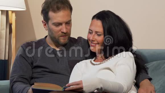 可爱的一对成熟的夫妇在一起看书时笑着视频的预览图