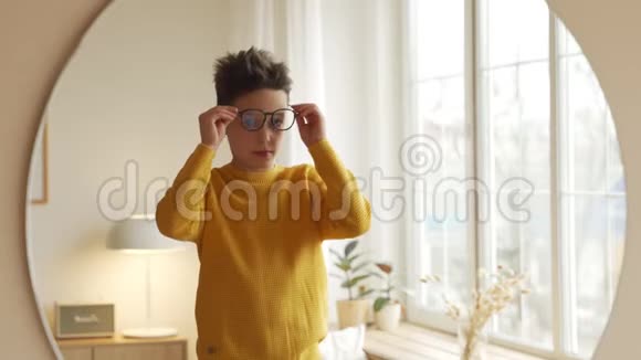 少年正在镜子前挑选新眼镜视频的预览图