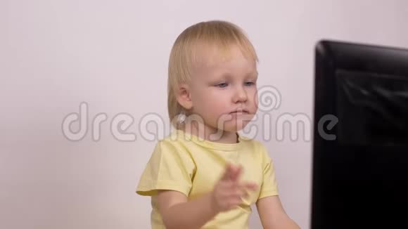 金发小女孩看着笔记本电脑情绪激动地摇着手指特写科技视频的预览图