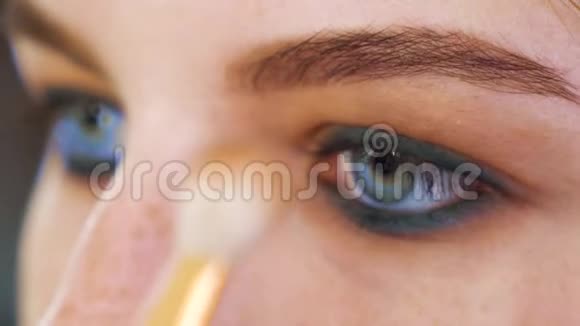 年轻女性用刷子完成专业眼妆视频的预览图
