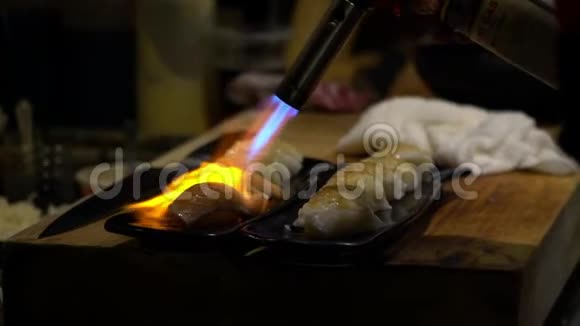 切夫的慢动作燃烧一条鱼用吹嘴使寿司焦糖化视频的预览图