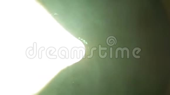一个人照亮了一束来自轮廓投影仪的光视频的预览图