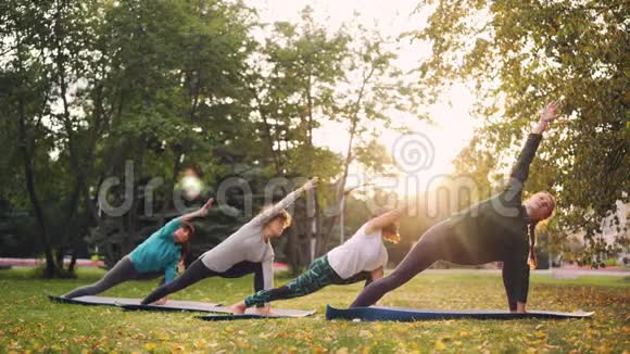 穿运动服的漂亮女人在秋天的晴天在公园里做瑜伽运动享受练习和锻炼视频的预览图