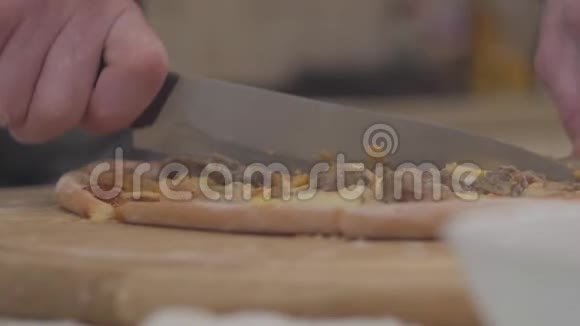 盘子木板上的披萨用刀子手工切割慢动作视频的预览图